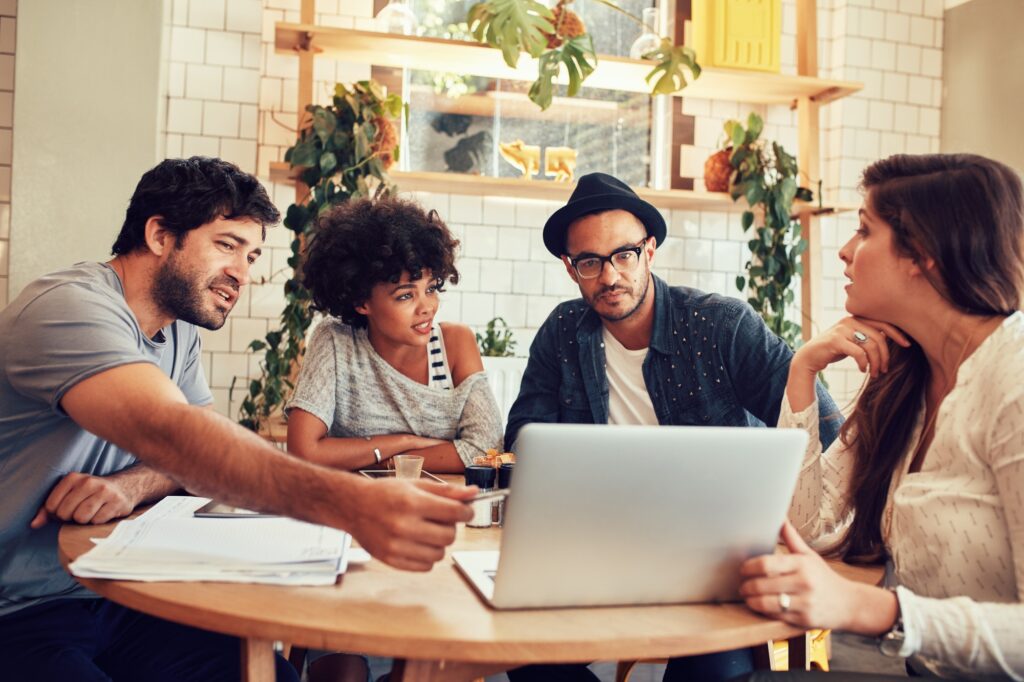 Creative team discussing new business project at a cafe